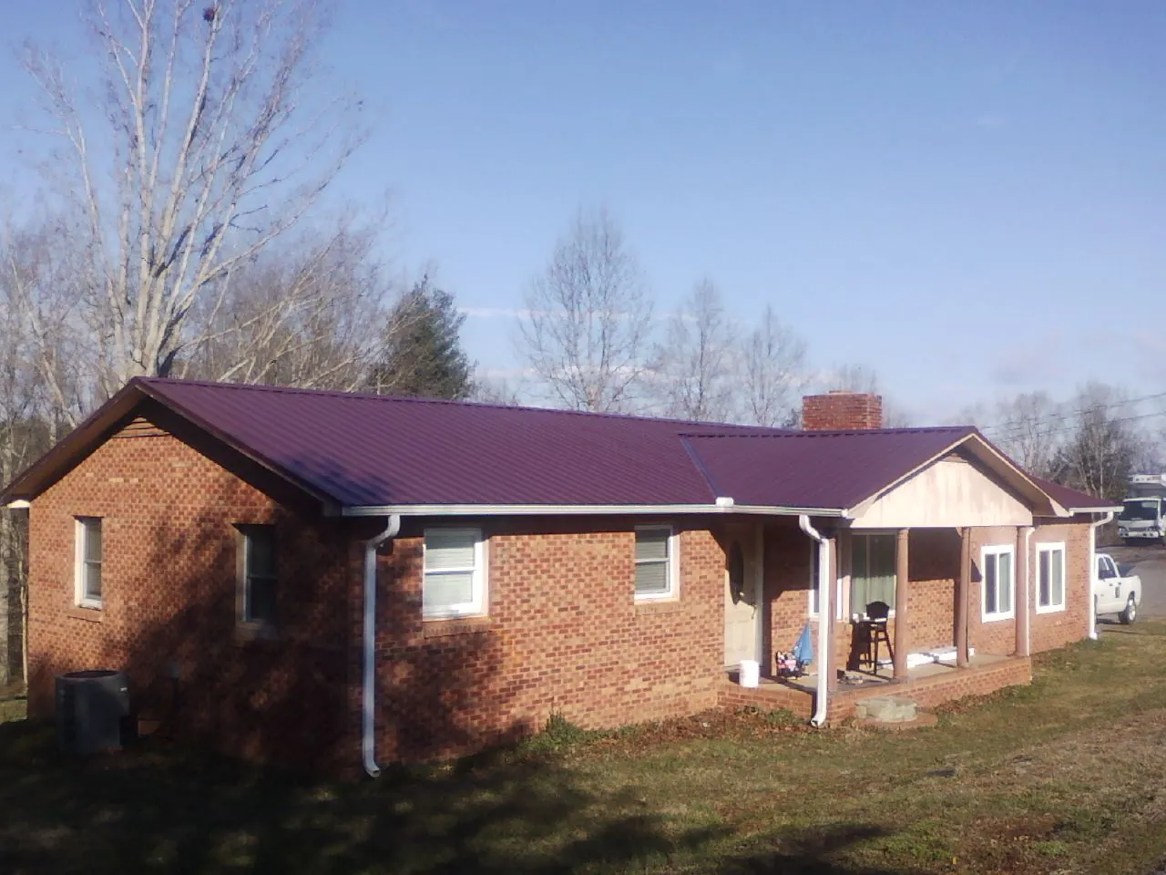 Burgundy metal roof on a brick ranch home with a new addition in Bethel