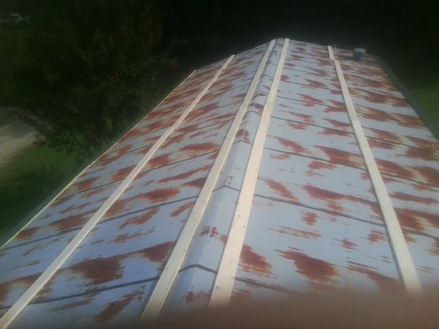 Rusted metal roof panels with new wood purlins before replacement — Storm Damage Roof Repair in Bethel by Roofing Brothers