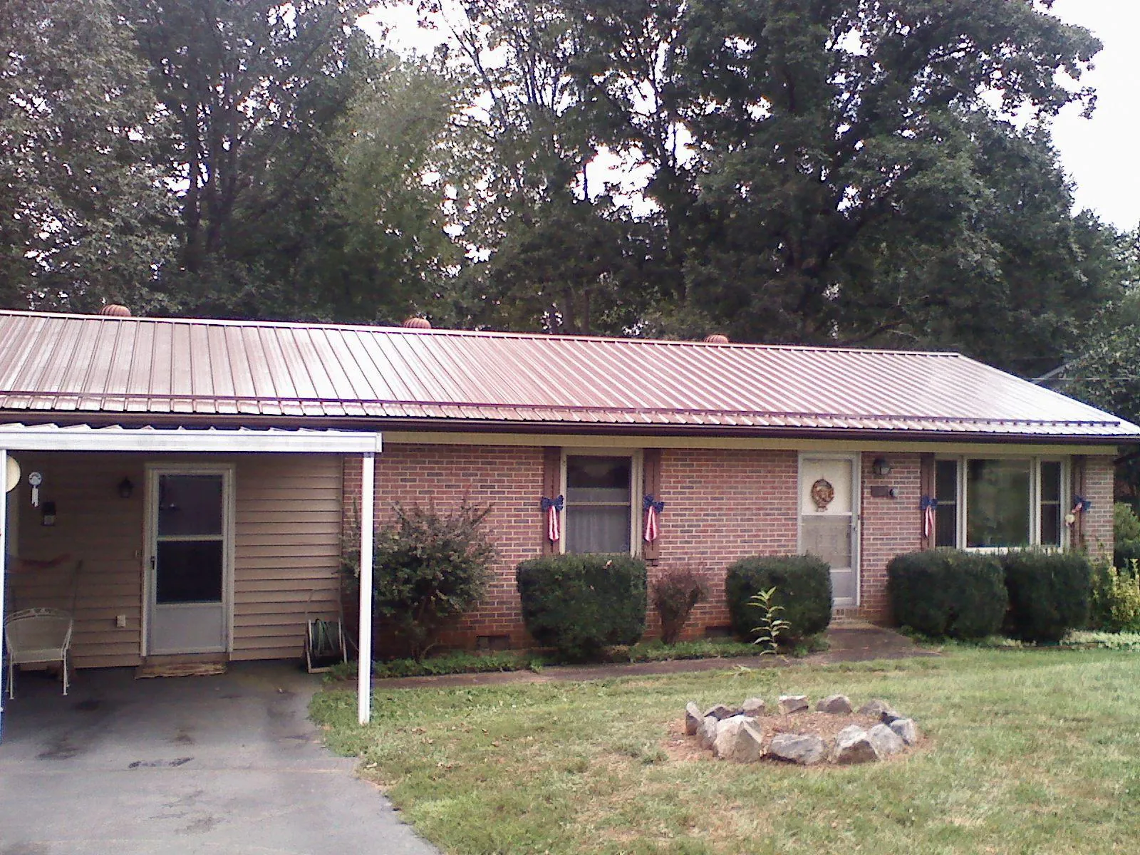 Bronze metal roof and carport on a brick ranch home — Roof Repair work by our crew in Bethel