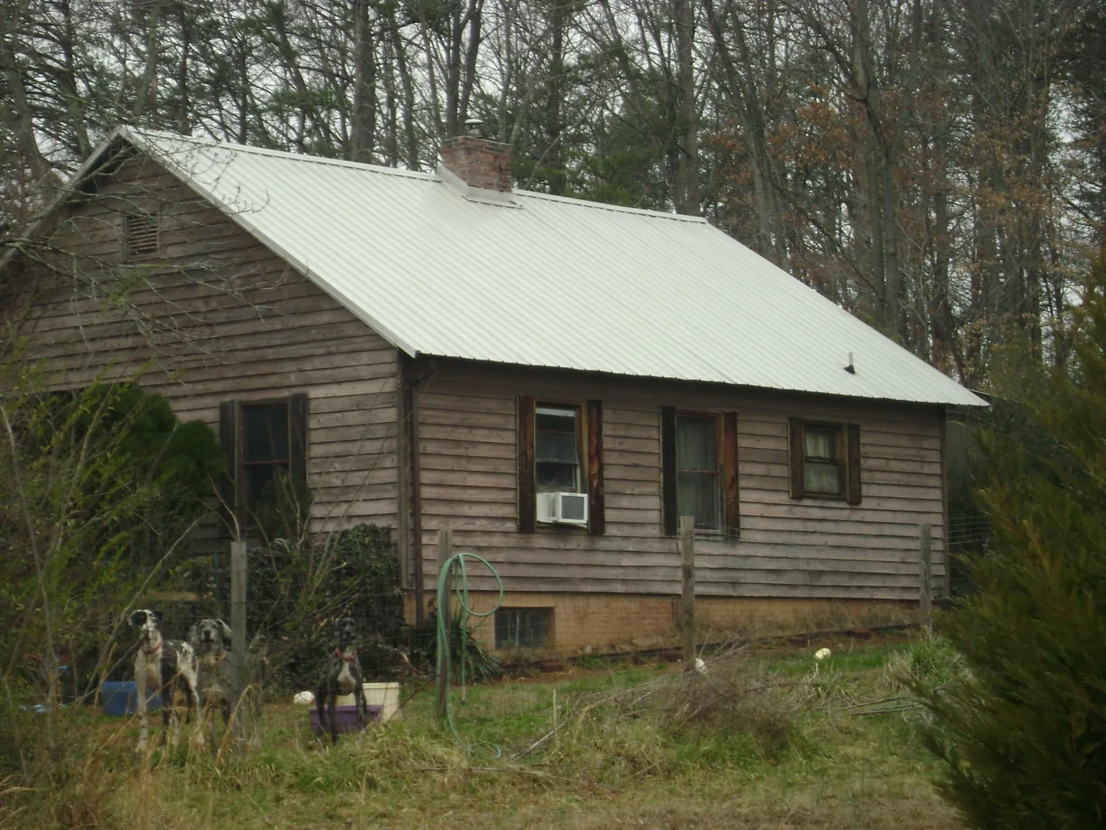 White metal roof on an old wood sided farmhouse, from a Metal Roof Installation job in Bethel